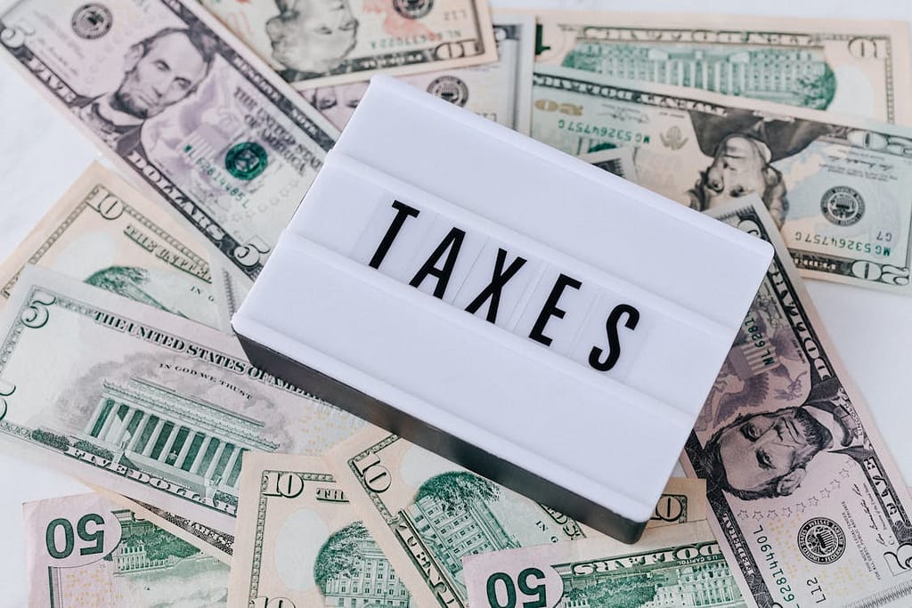 a small lightbox that says taxes on top of a pile of money