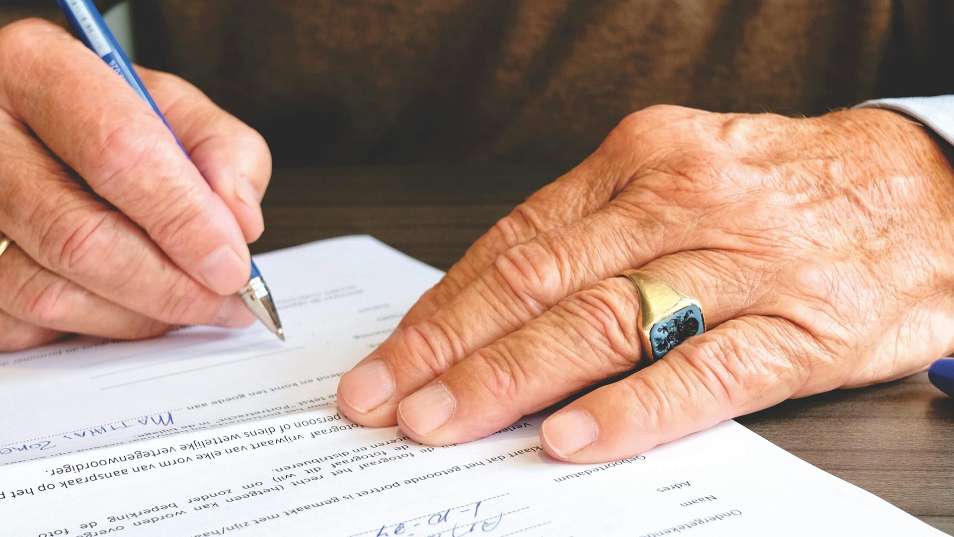 A man holding a pen and signing a document.